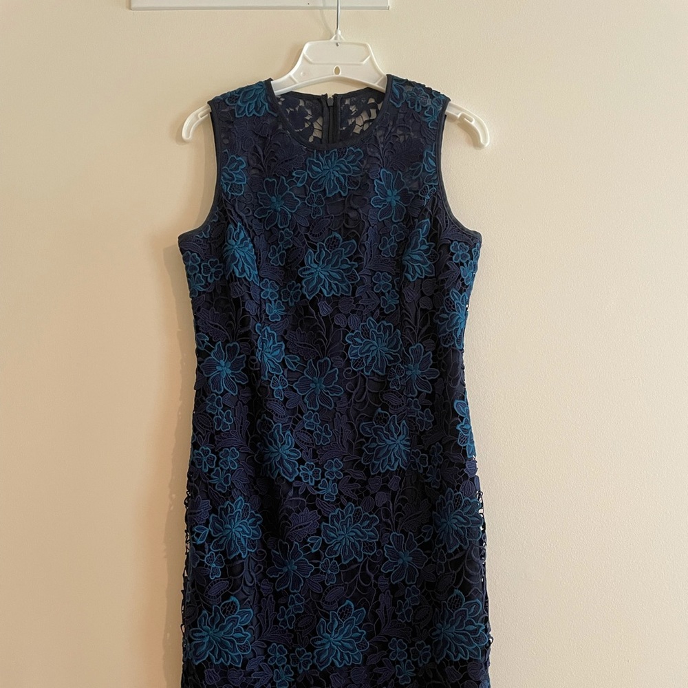 Embroidered lace, sheer neckline, back kick pleat, fully lined.